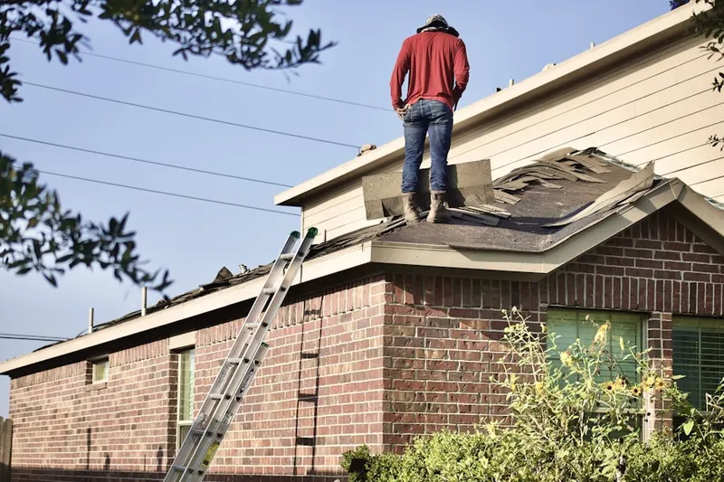 Professional roofer working on a residential roof in New London